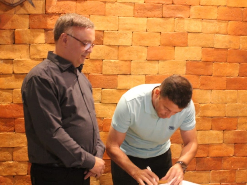 PREFEITO DE SANTA MARIA DE ITABIRA, Andr&eacute; Lucio Torres assinando o conv&ecirc;nio associativo, observado pelo presidente do CTMAM, H&eacute;lio An&iacute;cio